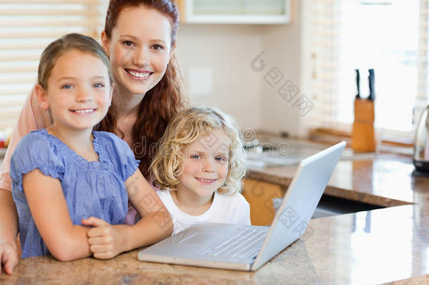 妈妈和孩子们在厨房里的笔记本电脑上
