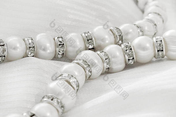 珍珠项链，丝绸上有亮丽的戒指