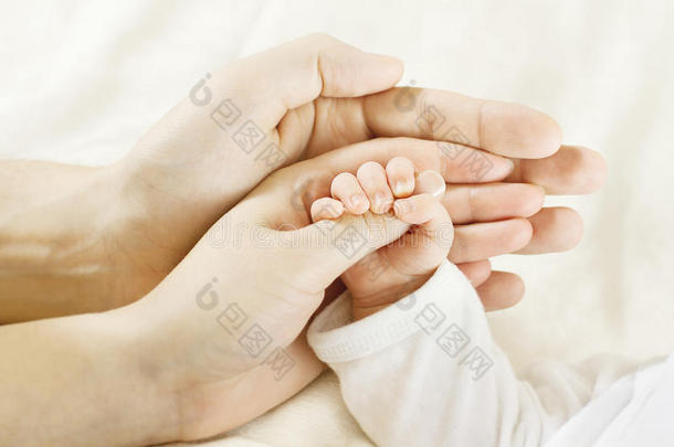 家庭婴儿手。爸爸妈妈抱着刚出生的孩子。儿童手