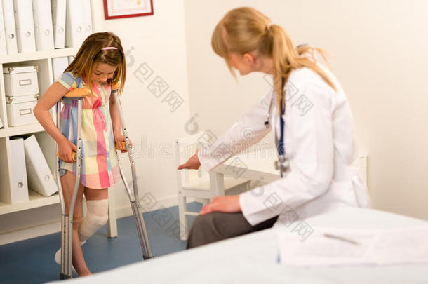 在儿科医生那里拄着拐杖的小女孩