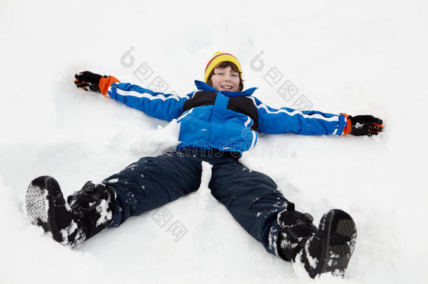 小男孩在斜坡上做雪天使