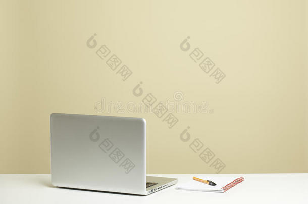 带记事本的白色桌上开放式笔记本电脑