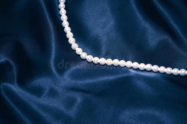 深蓝色丝绸上的白色珍珠项链