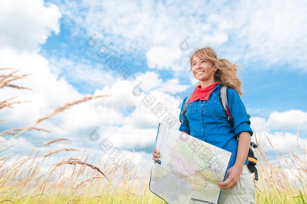 夏日田野里拿着地图的旅游妇女。