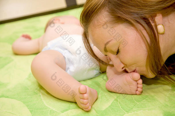 母亲亲吻她刚出生婴儿的小脚