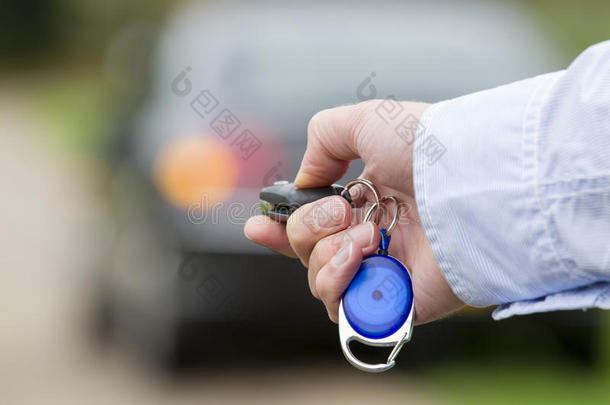 拿着汽车遥控钥匙的人。