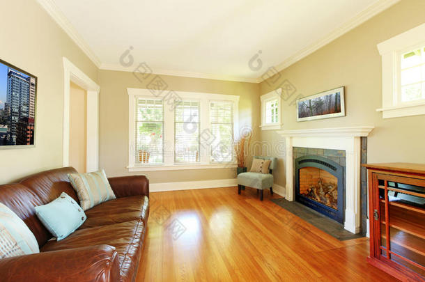 优雅的客厅配有壁炉，真皮沙发配有米色墙壁。
