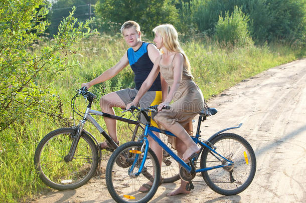 夏天在乡村公路上骑自行车的男孩和女孩