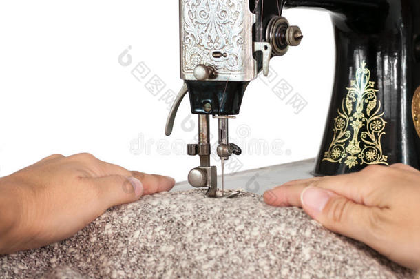 用手引导织物穿过老式缝纫机