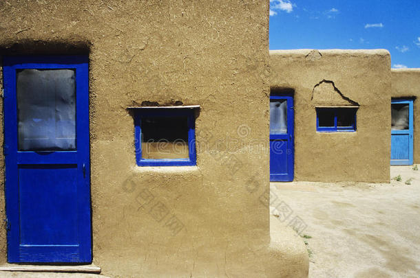 有蓝色窗户和门框的土坯房