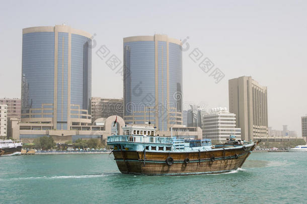 迪拜阿联酋一艘破釜沉舟的木制帆船沿着迪拜小溪在劳力士塔前航行。