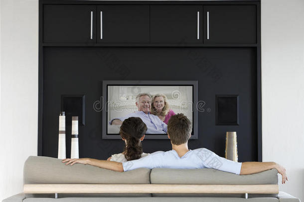 夫妇在客厅电视上<strong>看电影</strong>的背面