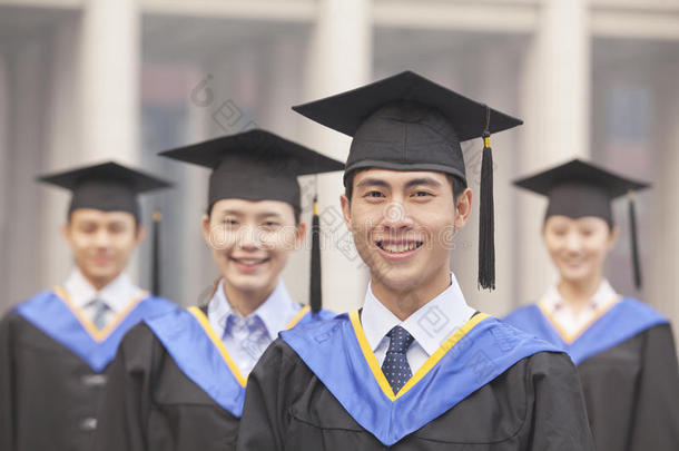 四个穿着<strong>毕业</strong>礼服和迫击炮微笑的<strong>大学毕业</strong>生，看着镜头