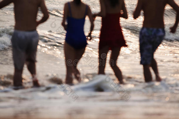 四个朋友在沙滩<strong>上下</strong>水，剪影