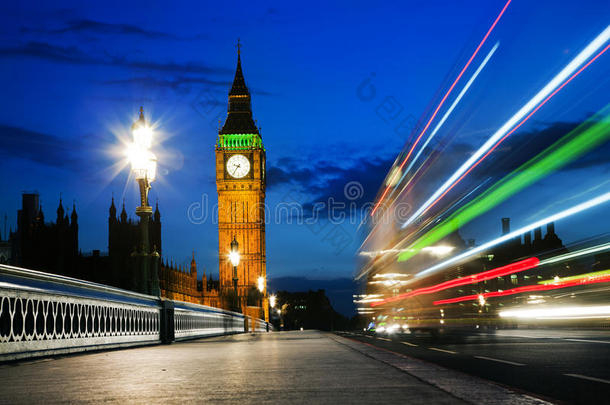 伦敦，英国。红色大巴在行驶，大本钟在夜间
