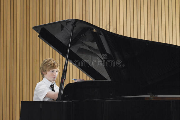 音乐课上弹钢琴的男孩