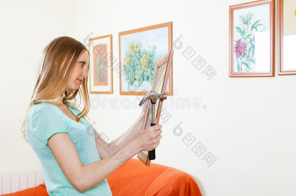 年轻女子在家挂画