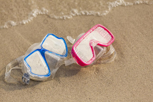 夏令时：海边沙滩上的红蓝两色护目镜