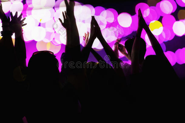 观众观看摇滚表演，手举在空中，后视图，<strong>舞台灯</strong>光