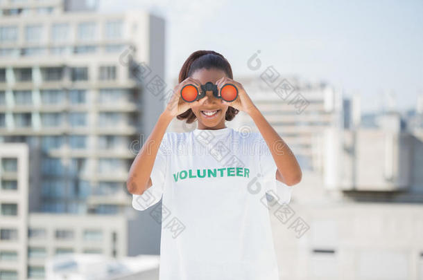 用双筒望远镜看志愿者T恤的微笑女子