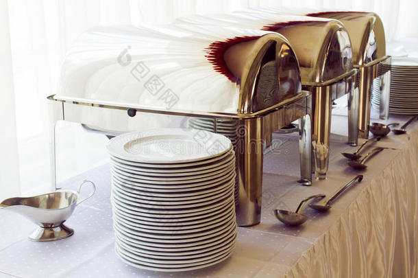 餐桌上的金属厨房设备和盘子，用于精致的婚宴或其他盛宴