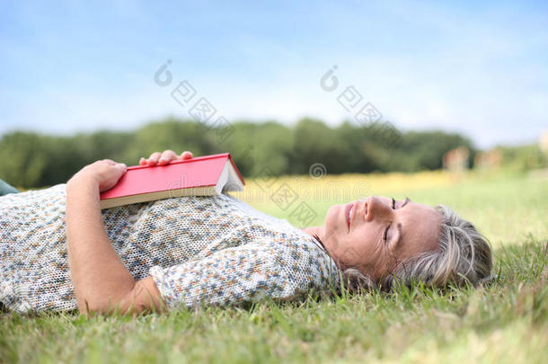 躺在草地上<strong>翻开</strong>书本的女人