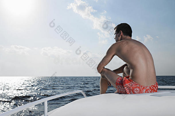坐在游艇边上看海的人