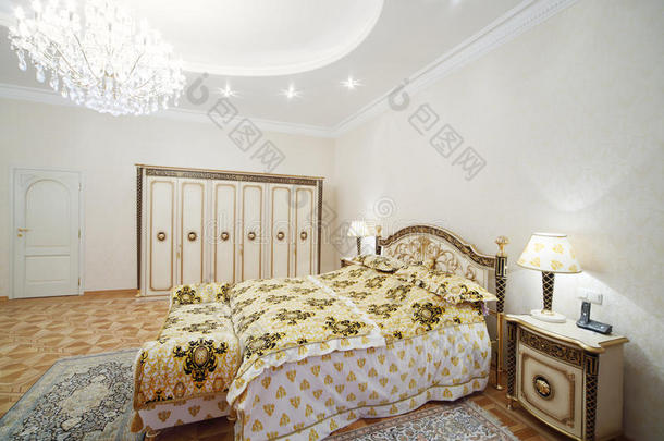 豪华卧室，配有镀金双人床和床头柜