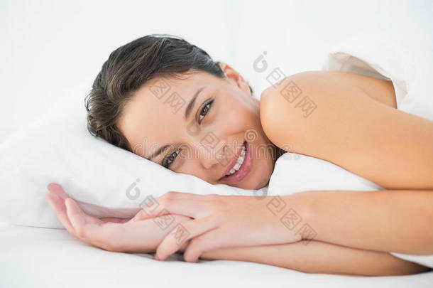 躺在床上微笑的浅褐色女人