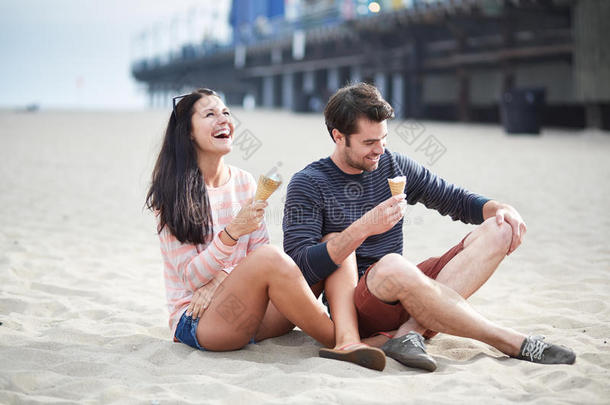 一对夫妇坐在<strong>圣莫尼卡</strong>码头的沙滩上。
