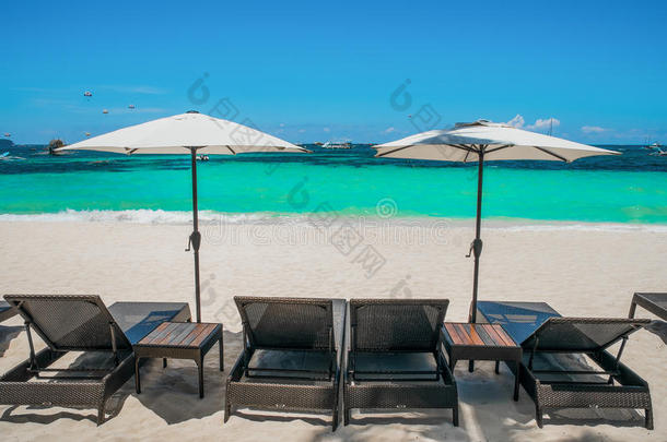 海滩雨伞和躺椅在完美的白色海滩上