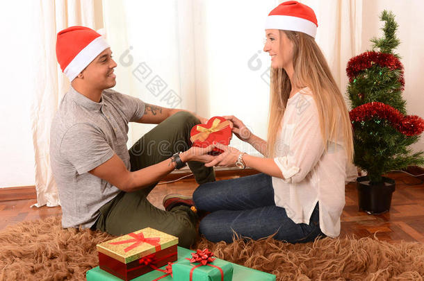 圣诞节小情侣在地毯上送礼物