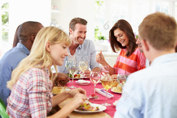 一群朋友围坐在桌旁开<strong>晚宴</strong>