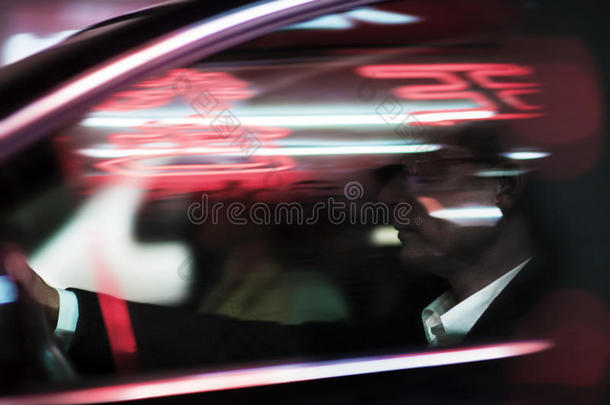商人晚上开车，在车窗上照明和反射灯