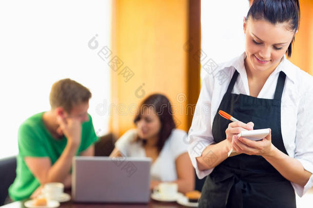 女服务员在咖啡店用笔记本电脑和学生们一起写订单