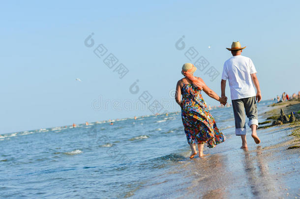 幸福的成熟夫妻手牵手漫步<strong>海滨沙滩</strong>