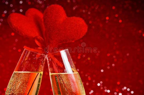 两支香槟长笛配上金色泡泡和红色天鹅绒心形，在红色波基背景下发出<strong>欢呼声</strong>