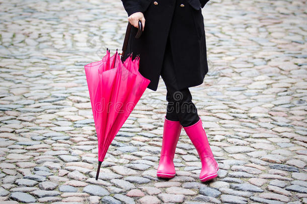 粉色雨伞和粉色橡胶靴