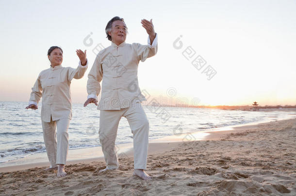 两位老人日落时在海滩上练习<strong>太极</strong>拳