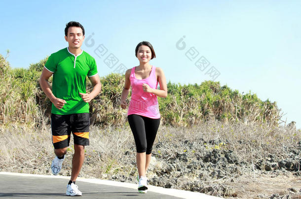 一对年轻夫妇在慢跑跑道上一起跑步