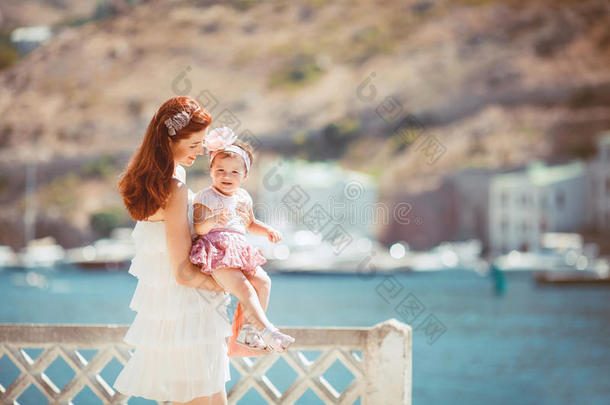 夏日蓝海边嬉戏的妇幼幸福家庭写真