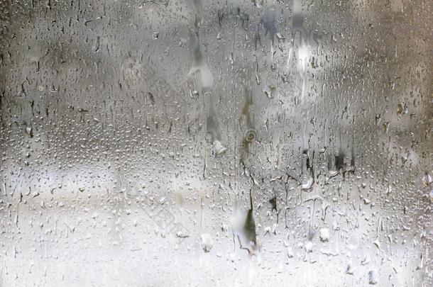 冰冻的水滴落在磨砂玻璃上。冬季纹理背景。