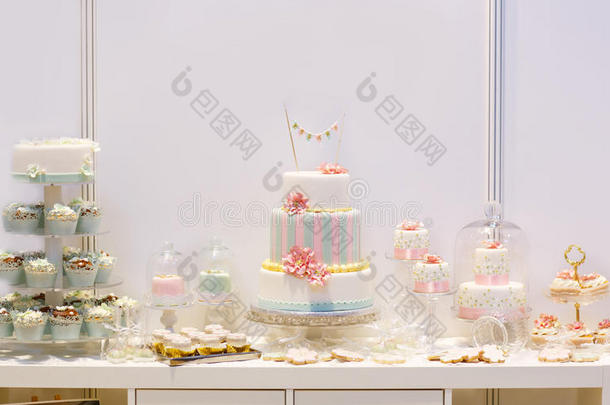优雅甜美的餐桌，有大蛋糕、纸杯蛋糕、晚餐上的蛋糕