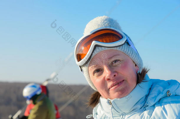 在山坡上戴着帽子和滑雪镜的中年黑发女人