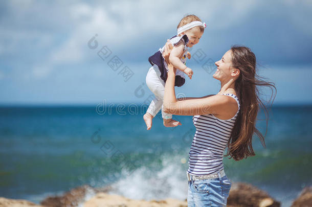 夏日蓝海边嬉戏的妇幼幸福家庭写真