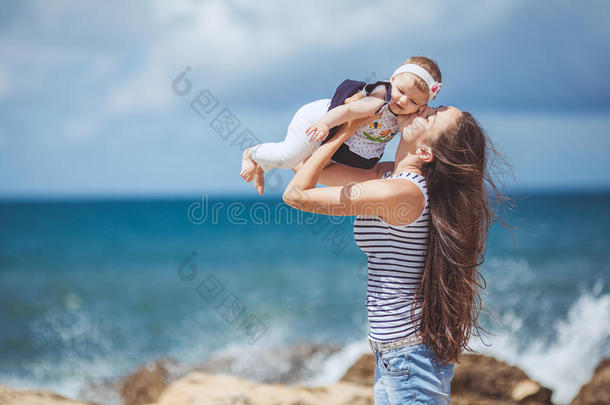 夏日蓝海边嬉戏的妇幼幸福家庭写真