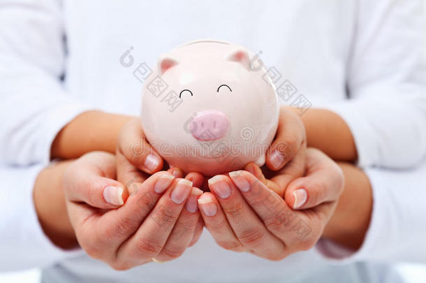 金融教育理念-成人和儿童手举存钱罐