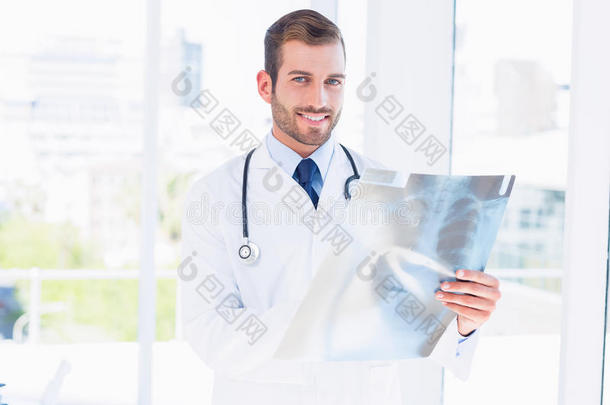 微笑的年轻男医生检查x光片的照片