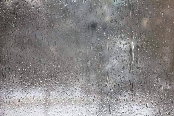 冰冻的水滴落在磨砂玻璃上。冬季纹理背景。