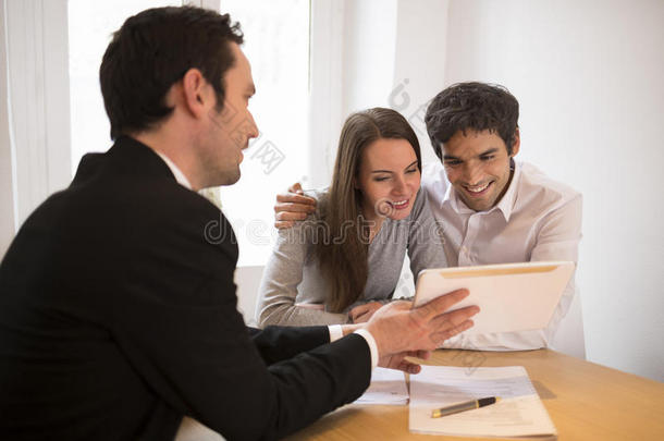 年轻夫妇相约<strong>房产</strong>中介买房，在平板电脑上演示